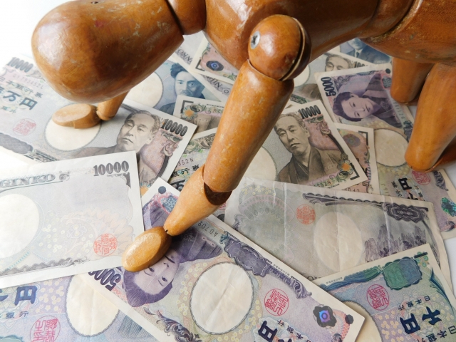 お金の上でうなだれる。出雲市の司法書士や弁護士に無料で相談できます